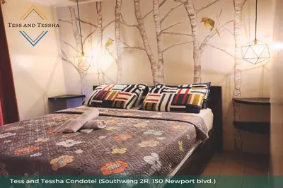 a bedroom with a bed with a tree mural on the wall at Tess and Tessha Condotel near T3 Airport in Manila