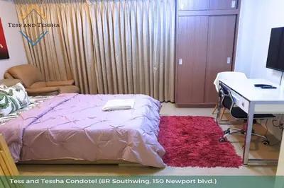 a bedroom with a bed and a desk and a computer at Tess and Tessha Condotel near T3 Airport in Manila