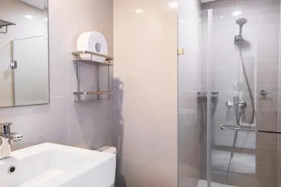 a bathroom with a white sink and a shower at Tess and Tessha Condotel near T3 Airport in Manila