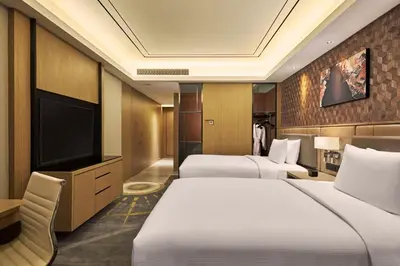 a hotel room with two beds and a flat screen tv at Hilton Manila Newport World Resorts in Manila