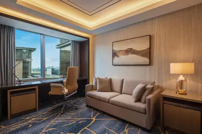 a living room with a couch and a desk and a window at Hilton Manila Newport World Resorts in Manila
