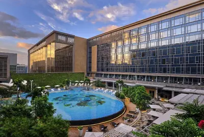 a hotel with a large pool in front of a building at Hilton Manila Newport World Resorts in Manila