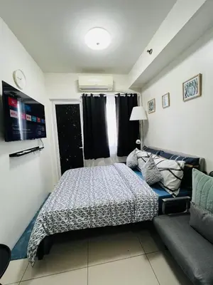 a bedroom with a bed and a couch at Sea Breeze Studio Manila in Manila