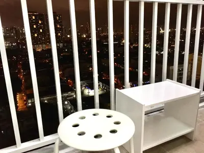 a white desk and a chair in front of a window at Sea Breeze Studio Manila in Manila