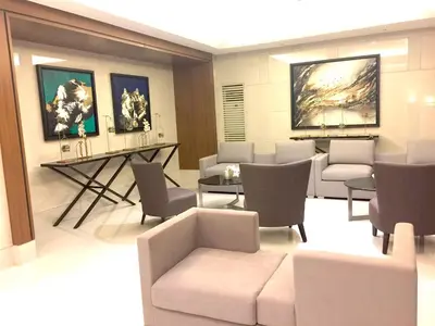 a waiting room with chairs and tables and paintings at Sea Breeze Studio Manila in Manila
