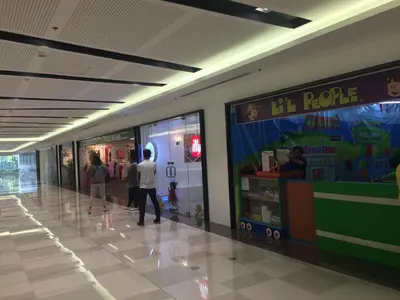 a man walking down a hallway in a shopping mall at Sea Breeze Studio Manila in Manila