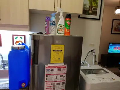 a refrigerator with cleaning products on top of it at Modern Urban Living - Resort Amenities in Manila