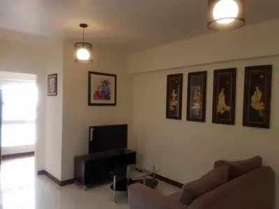 a living room with a couch and a tv at Modern Urban Living - Resort Amenities in Manila