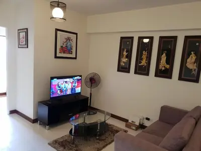 a living room with a couch and a flat screen tv at Modern Urban Living - Resort Amenities in Manila
