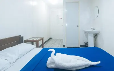 a bedroom with a white swan towel on a bed at Metro Deluxe Residences near World Trade Center in Manila