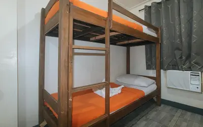 a bunk bed in a room with an orange bunk bed at Metro Deluxe Residences near World Trade Center in Manila