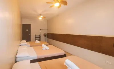 a row of beds in a room at Metro Deluxe Residences near World Trade Center in Manila
