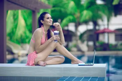 a woman sitting next to a pool brushing her teeth at Mount Sea Resort in Rosario