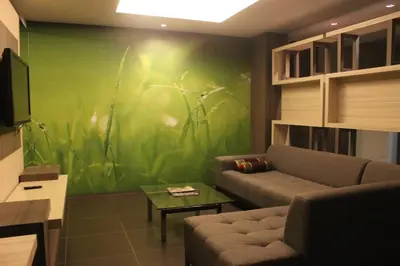 a living room with a couch and a green wall at Mount Sea Resort in Rosario
