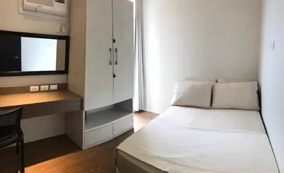 a bedroom with a bed and a desk and a tv at Portovita Towers in Manila