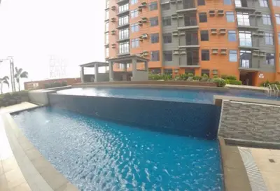 a large swimming pool in front of a building at Portovita Towers in Manila