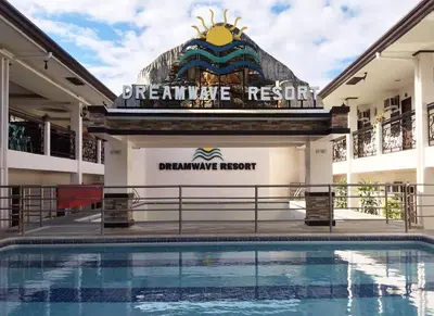 a hotel with a swimming pool in front of a sign at Dreamwave Resort Pansol Laguna in Calamba