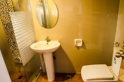a bathroom with a sink and a mirror and a toilet at Dreamwave Resort Pansol Laguna in Calamba