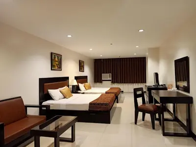 a hotel room with a bed and a table and chairs at Paragon Tower Hotel in Manila