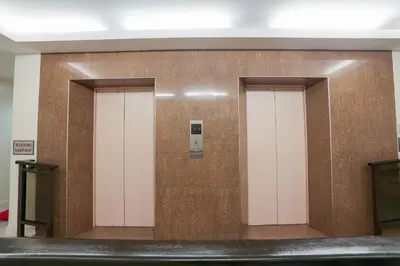 two elevators in a room with a wall at Paragon Tower Hotel in Manila