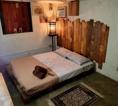 a bed with a brown teddy bear sitting on it at Marius B&B & Hostel in Silang