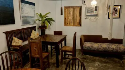 a dining room with a wooden table and chairs at Marius B&B & Hostel in Silang
