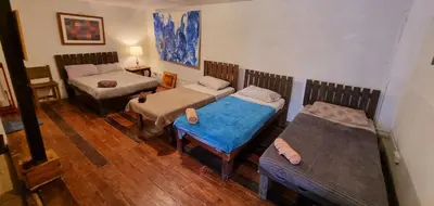 a room with two twin beds and a couch at Marius B&B & Hostel in Silang