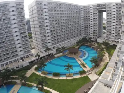 an overhead view of a large pool in a city with tall buildings at RLR Condo at Shell Residences in Manila