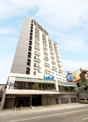 a large white building with a sign on it at Lub d Manila Makati - Central Makati, Near Nightlife in Manila