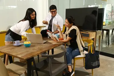 a group of people sitting around a table with a laptop at Lub d Manila Makati - Central Makati, Near Nightlife in Manila