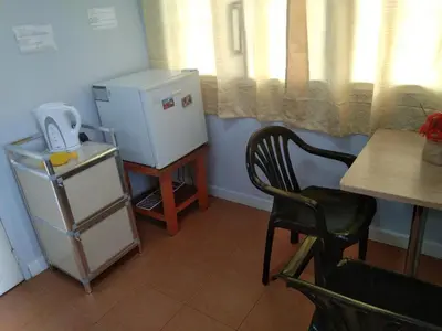 a kitchen with a refrigerator and a table and a chair at The Terrace Room in Manila