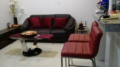 a living room with a couch and a table and chairs at Burgundy McKinley Place in Manila