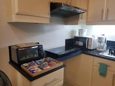 a kitchen with a counter top with a microwave and a stove at Morgan Suites in Manila