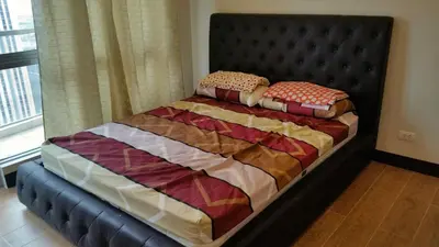 a bed in a bedroom with a black headboard at Morgan Suites in Manila