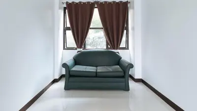 a green chair in a room with a window at RedDoorz at San Antonio Makati in Manila