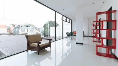 a living room with a chair and some windows at RedDoorz at San Antonio Makati in Manila