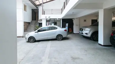 a white car parked in a parking lot at RedDoorz at San Antonio Makati in Manila