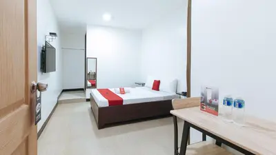 a bedroom with a bed and a table and a mirror at RedDoorz at San Antonio Makati in Manila