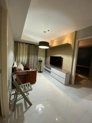 a living room with a couch and a television at Azure Urban Resort and Residences by Rosary in Manila