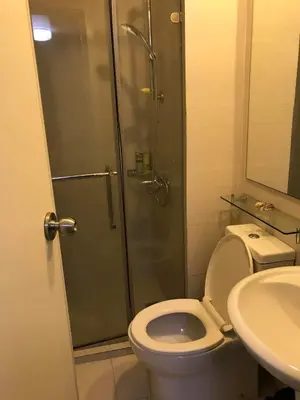 a bathroom with a shower and a toilet and a sink at Azure Urban Resort and Residences by Rosary in Manila