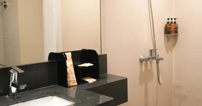 a bathroom with a sink and a mirror at Savoy Hotel Manila near Airport NAIA Terminal 3 MNL in Manila