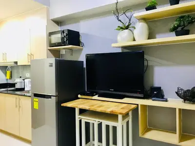 a kitchen with a refrigerator and a tv on a counter at Manila Bay Breeze Residences with Pool View in Manila