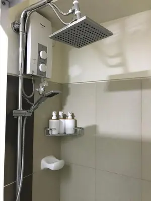 a shower in a bathroom with a shower head at Manila Bay Breeze Residences with Pool View in Manila