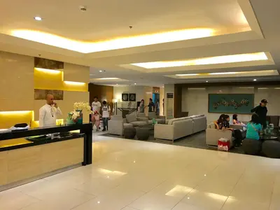 a lobby of a hotel with people sitting on couches at Manila Bay Breeze Residences with Pool View in Manila