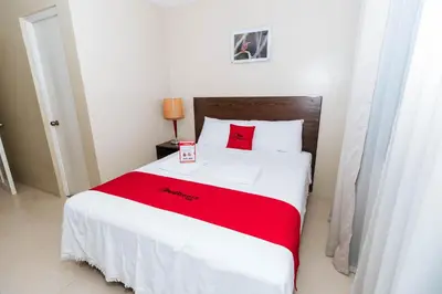 a bedroom with a bed with a red blanket at RedDoorz near Osmena Highway 1 in Manila
