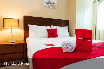 a hotel room with a bed with red and white pillows at RedDoorz near Osmena Highway 1 in Manila
