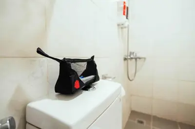 a black bag sitting on top of a toilet in a bathroom at RedDoorz near Osmena Highway 1 in Manila