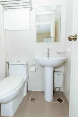 a white bathroom with a sink and a toilet at RedDoorz near Osmena Highway 1 in Manila