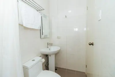 a white bathroom with a toilet and a sink at RedDoorz near Osmena Highway 1 in Manila