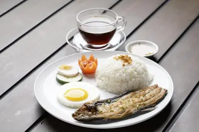 a plate of food with rice and an egg and a cup of coffee at Achievers Airport Hotel in Manila